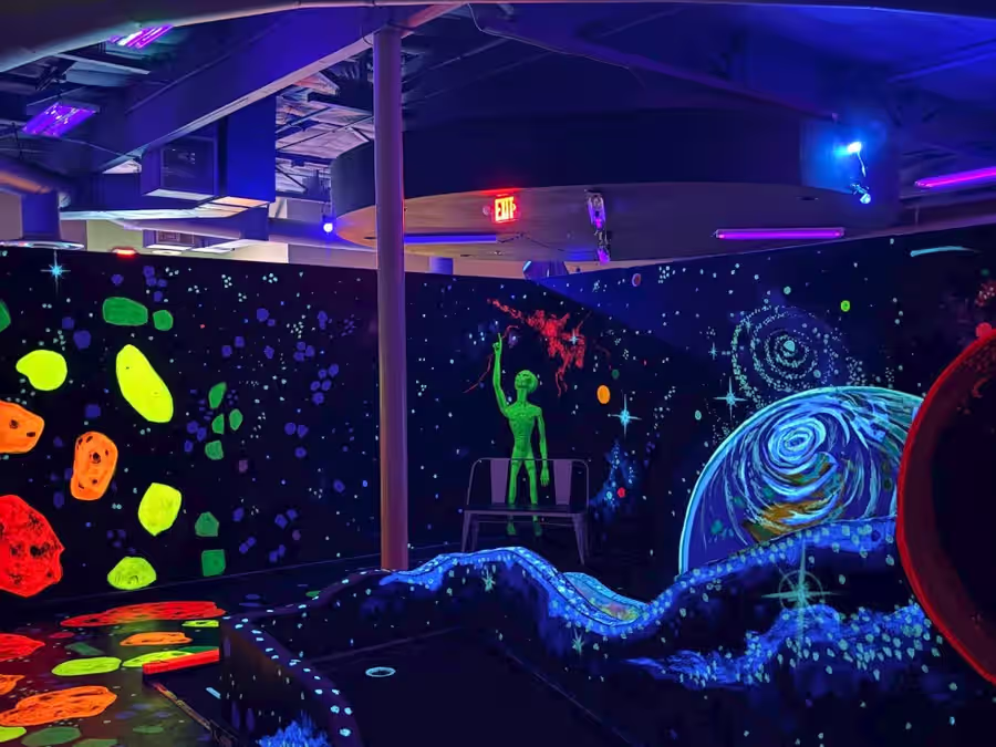 Alien statue among an asteroid field mural at Gilbert